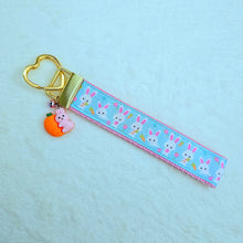 Load image into Gallery viewer, Bunnies with Carrots &amp; Flowers on Light Blue Yellow Gold Key Chain Fob with Enameled Bunny Charm
