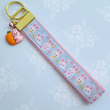 Load image into Gallery viewer, Bunnies with Carrots &amp; Flowers on Light Blue Yellow Gold Key Chain Fob with Enameled Bunny Charm

