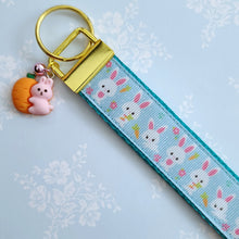 Load image into Gallery viewer, Bunnies with Carrots &amp; Flowers on Light Blue Yellow Gold Key Chain Fob with Enameled Bunny Charm
