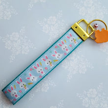 Load image into Gallery viewer, Bunnies with Carrots &amp; Flowers on Light Blue Yellow Gold Key Chain Fob with Enameled Bunny Charm
